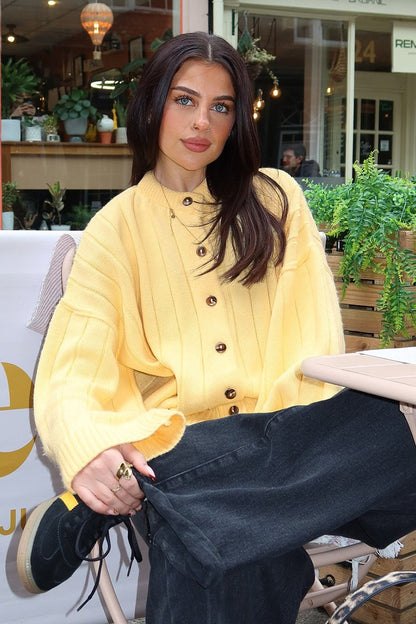 Cárdigan de punto amarillo con cuello redondo y canalé