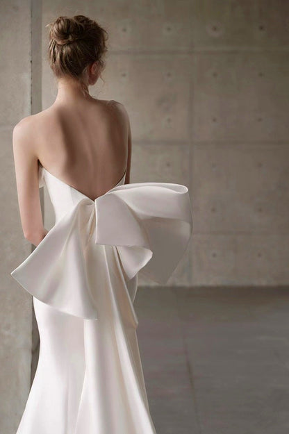 Vestido de novia de raso con escote palabra de honor, cola y lazo