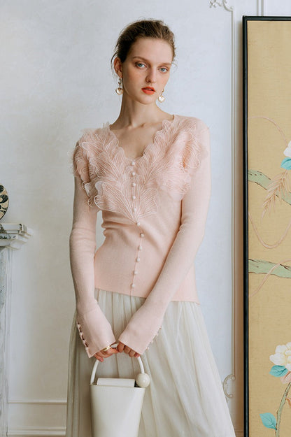 Top de punto con detalles de encaje y plumas