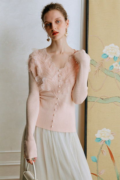 Top de punto con detalles de encaje y plumas