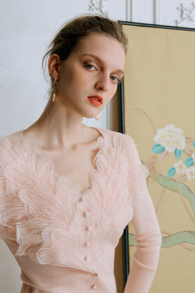 Top de punto con detalles de encaje y plumas