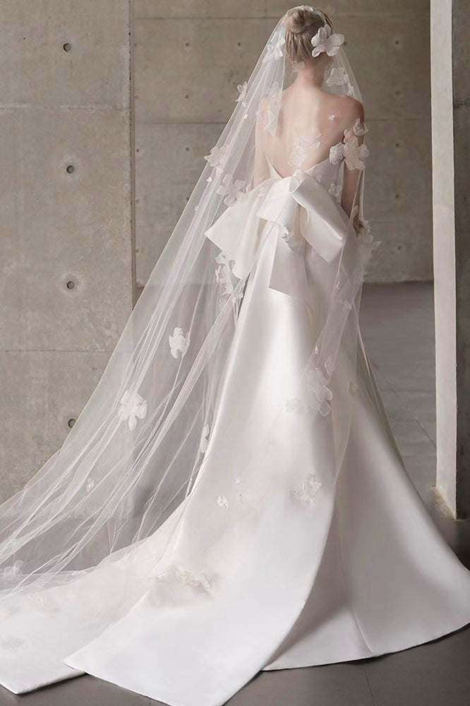 Vestido de novia de raso con escote palabra de honor, cola y lazo