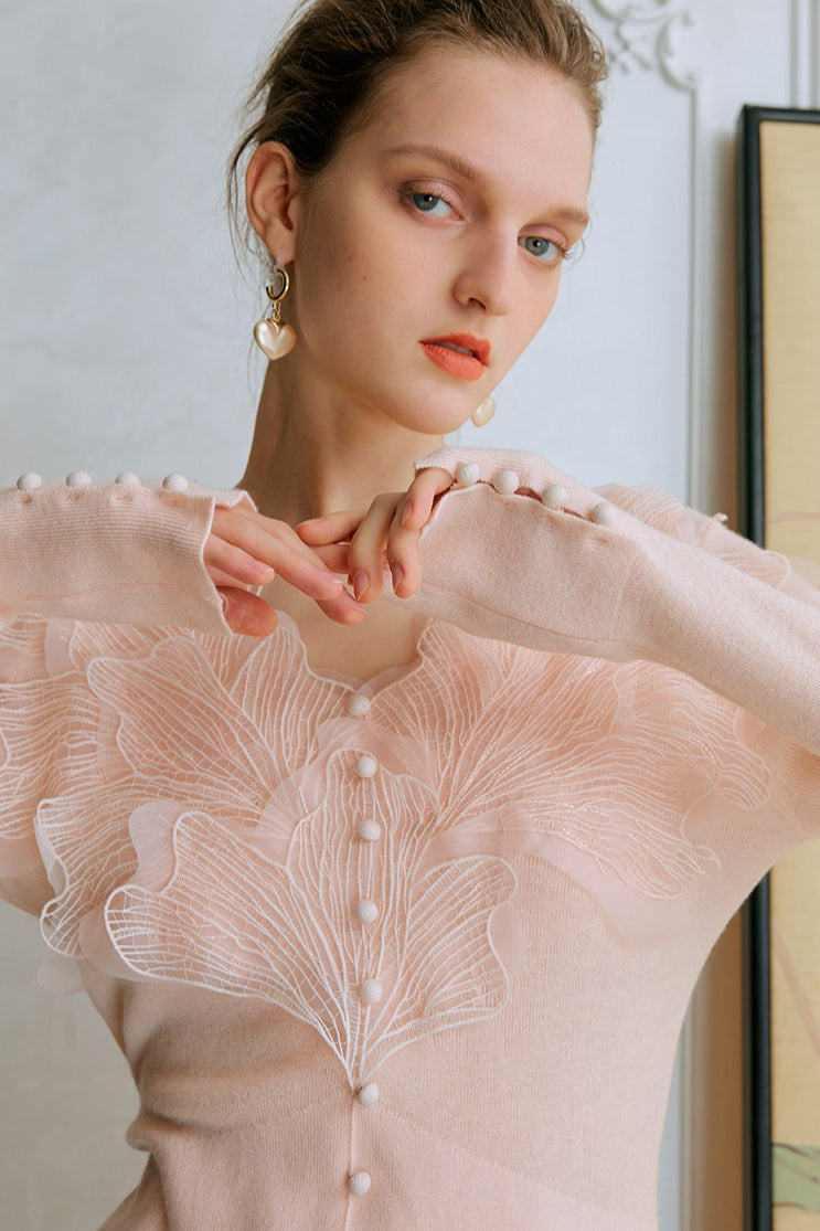 Top de punto con detalles de encaje y plumas