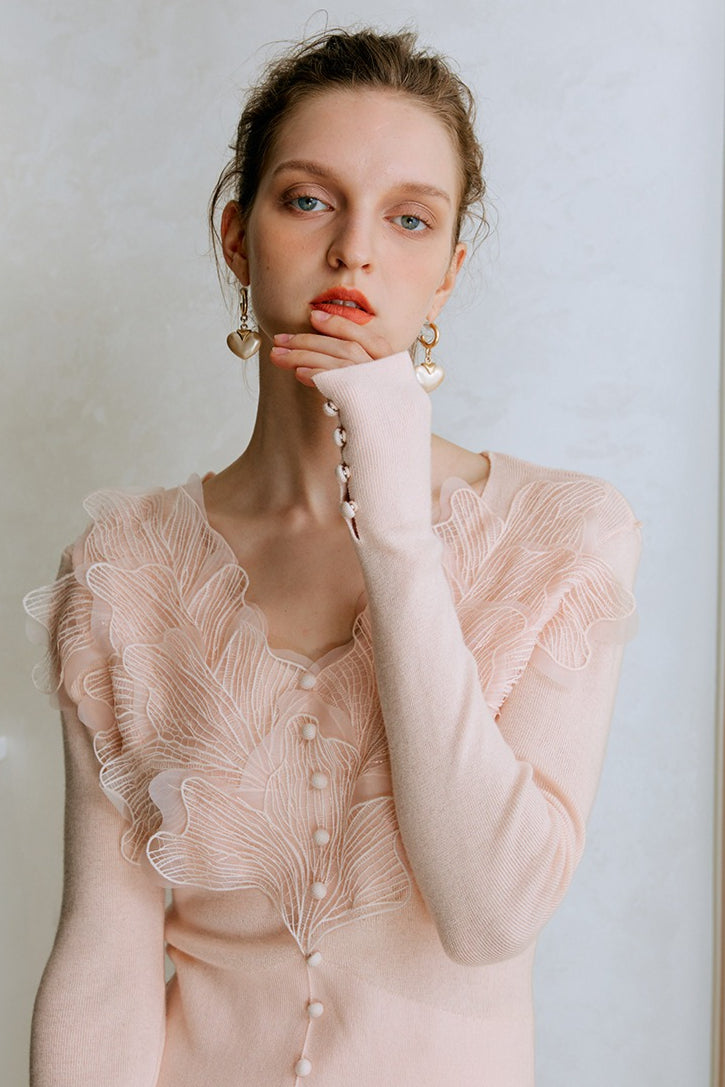 Top de punto con detalles de encaje y plumas