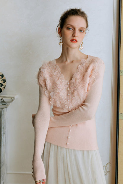 Top de punto con detalles de encaje y plumas